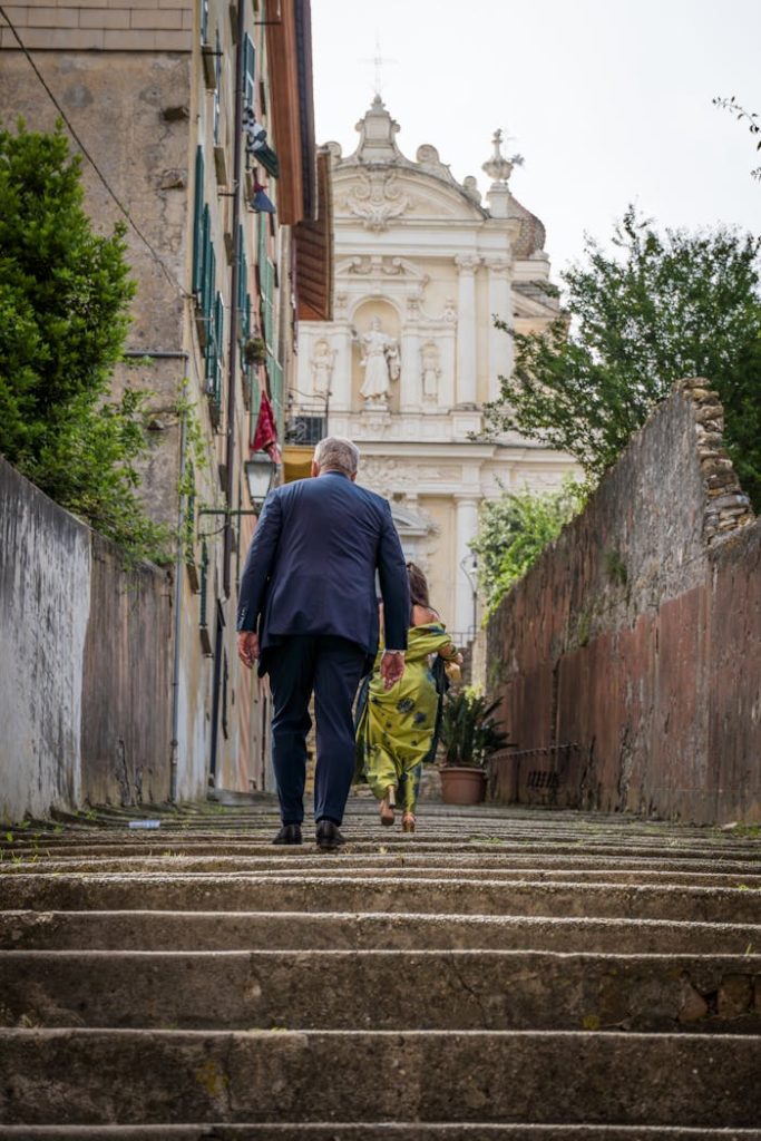 A couple walks up historic steps in Santa Margherita Ligure, Italy with scenic architecture.